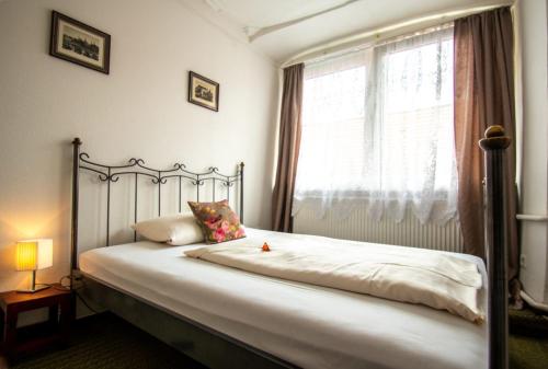 Schlafzimmer mit einem großen Bett und einem Fenster in der Unterkunft Gästehaus am weißen Turm in Rothenburg ob der Tauber