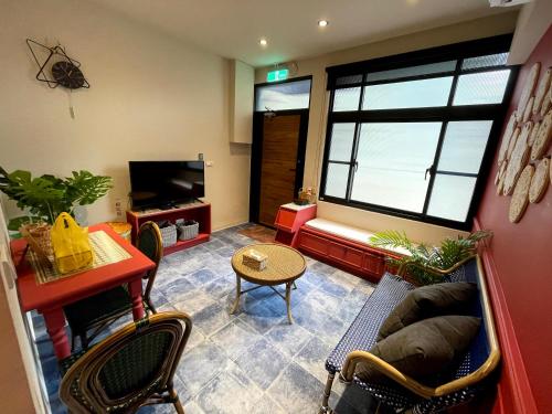 a living room with a couch and a tv at 三田包棟旅宿MITA Inn in Tainan