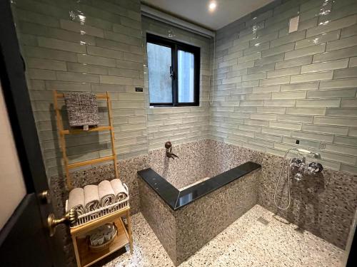 a bathroom with a large stone tub with a window at 三田包棟旅宿MITA Inn in Tainan