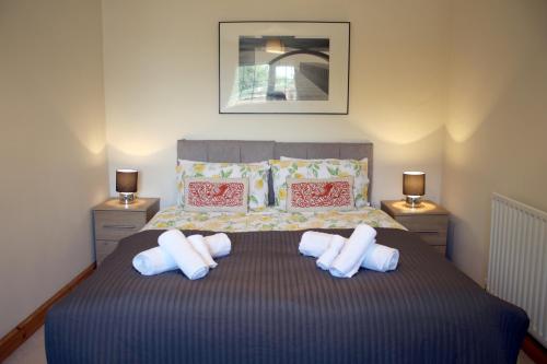 a bedroom with a bed with three pillows on it at Carvetii - Uriah House - 4-Bedroom House sleeps up to 10 people in Belle Vue