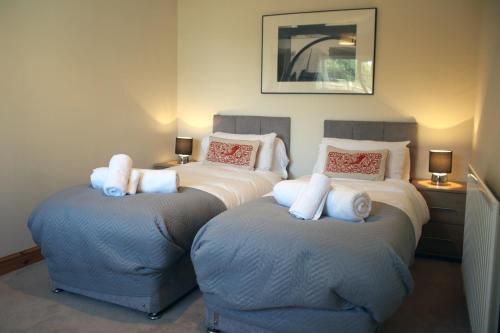 2 camas en una habitación con 2 reposapiés en Carvetii - Uriah House - 4-Bedroom House sleeps up to 10 people, en Belle Vue