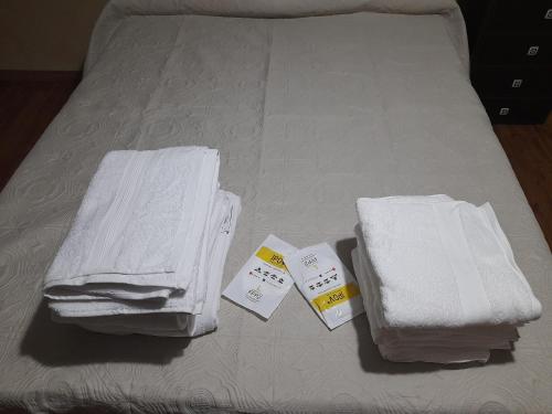 a bed with white towels and price tags on it at Apartamento Lucia in Granadilla de Abona