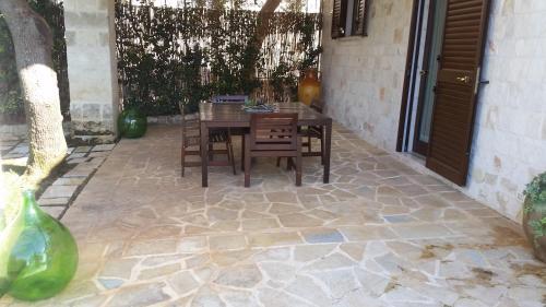 a patio with a table and chairs on a stone floor at Villa Mest Pepp in Monopoli