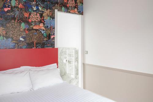 a bedroom with a white bed and a painting on the wall at Hôtel 31 - Paris Tour Eiffel in Paris