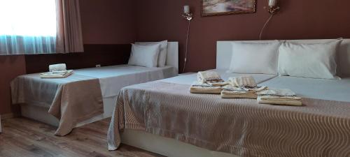 two beds in a hotel room with towels on them at MARIANA - guest rooms in Gotse Delchev