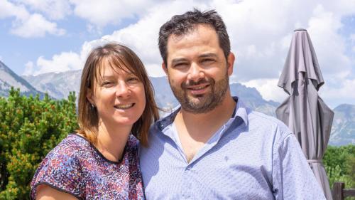 a man and a woman standing next to an umbrella at "La Combe Fleurie" Appartements & Chambres in Saint-Bonnet-en-Champsaur