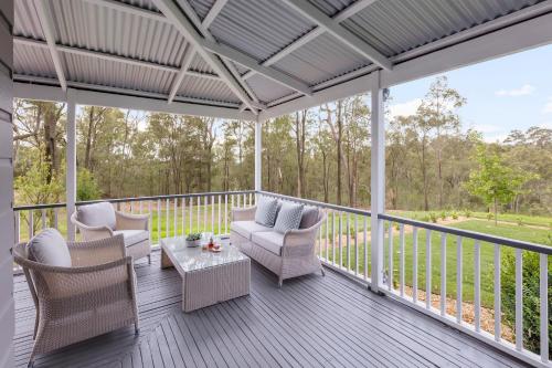 a screened in porch with chairs and a table at Spicers Guesthouse in Pokolbin