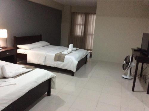 Habitación de hotel con 2 camas y TV en Casa Bel, en Baguio