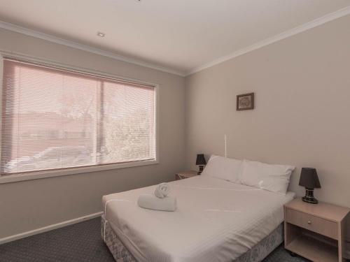 - une chambre avec un lit blanc et une fenêtre dans l'établissement 2 Munyang Street, à Jindabyne