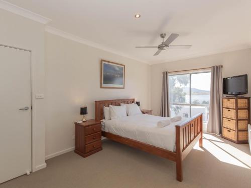 a bedroom with a bed and a tv and a window at Aspect 1 8a Poley Cow Lane in Jindabyne