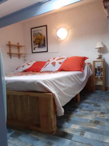 a bedroom with a bed with red and white pillows at L'Oustalet in Beaumes-de-Venise