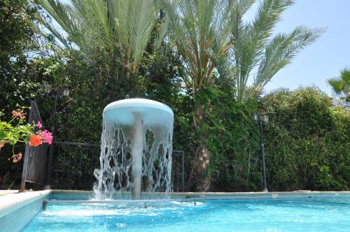 a fountain in the middle of a swimming pool at Mariela Hotel Apartments in Polis Chrysochous