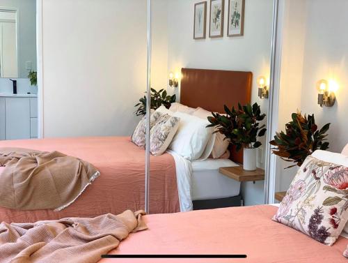 a bedroom with two beds and a mirror at Flower Farm Tamborine Mountain in Mount Tamborine