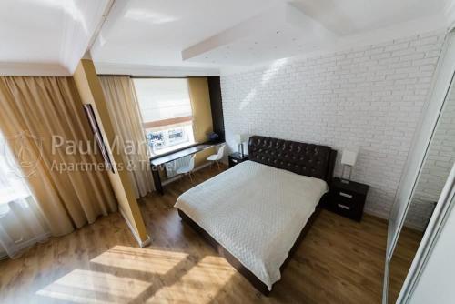 a bedroom with a bed and a brick wall at PaulMarieApartments on Sovetskaya in Brest