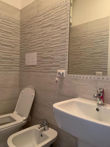 a bathroom with a sink and a toilet and a mirror at piccolo monolocale al porticciolo in Isola Rossa