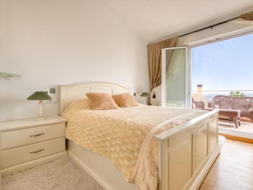 sypialnia z dużym łóżkiem i dużym oknem w obiekcie El Descanso w mieście Gata de Gorgos