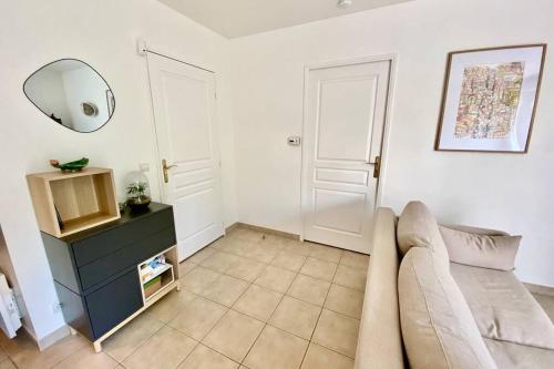 a living room with a couch and a mirror at La suite nature Disneyland Paris in Montévrain