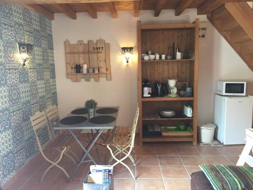 une petite cuisine avec une table et un réfrigérateur dans l'établissement location de chambre en petit duplex proche de la baie de Somme, à Bellancourt