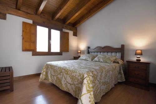 a bedroom with a bed and two night stands and a window at La Casona de los Cinco Caños in Coca
