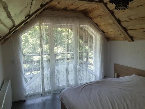 een slaapkamer met een bed en een raam met een balkon bij Vila Brandusa in Bran