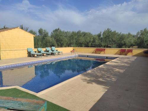 a swimming pool with two lawn chairs at LOS ABUELOS in Setenil
