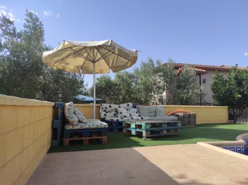 a patio with an umbrella and chairs and a table at LOS ABUELOS in Setenil