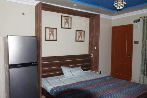 a small bedroom with a bed and a refrigerator at Entire Home's for family in Karachi