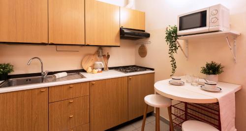 una pequeña cocina con fregadero y microondas en ALTIDO Charming Flat for 4, Near Train Station en Como