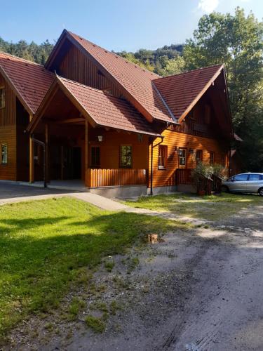 a large wooden house with a car parked in front at Schutzhaus Johannesbachklamm in Unterhöflein