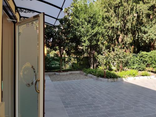 an open door to a courtyard with trees at La Bella Modena Centro in Modena