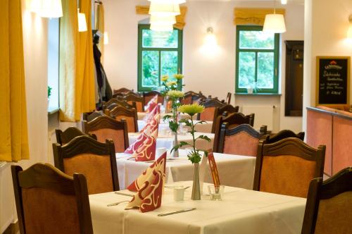 a dining room with tables and chairs with flowers on them at Gutshof Hauber in Dresden