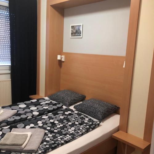 a bed with black and white sheets and pillows at Csorvy Apartman in Hajdúszoboszló