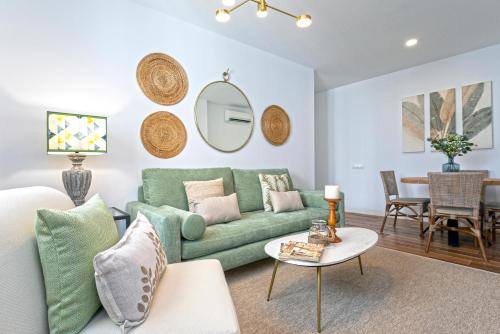 a living room with a green couch and a table at Genteel Home San Antonio in Cádiz