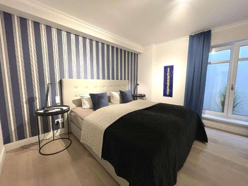 - une chambre avec un grand lit et une fenêtre dans l'établissement Sellmi Sylt @Haus Mateika, à Westerland