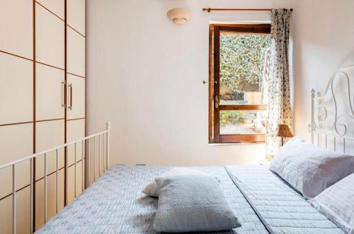 1 dormitorio con cama con espejo y ventana en Villetta a schiera con giardino - porto pollo en Porto Pollo