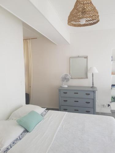 a bedroom with a bed and a dresser and a mirror at Charmant 2 pièces en plein coeur du village in Cargèse