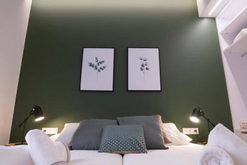 a bedroom with three pictures on a green wall with a bed at Dos Torres Exclusivos en Calle Alfonso I in Zaragoza