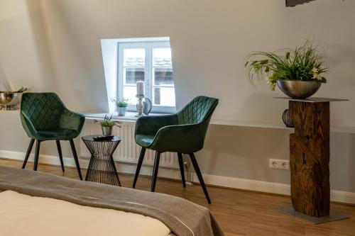 聖馬丁的住宿－Hotel zur Krone，窗户客房内的两张绿色椅子