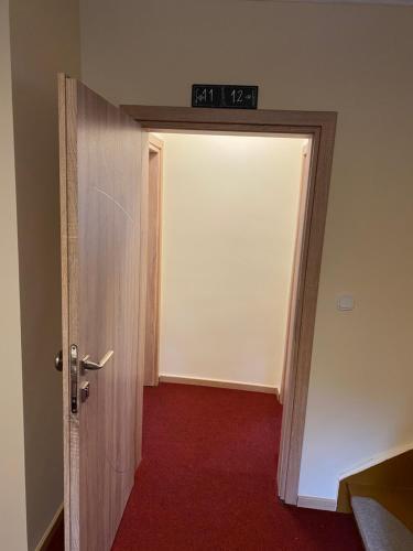 an open door to a room with a red carpet at Gasthof zur Post - Standort Am Bahnhof Eiserfeld in Siegen
