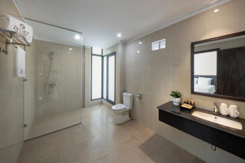 un bagno con wc, doccia e lavandino di Ivory Villas and Resort a Hòa Bình