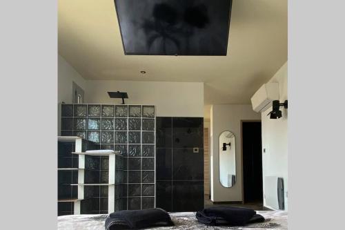 a bathroom with a black and white tiled wall at Rêves de vie, le "Port Miou" perle rare à Cassis in Cassis