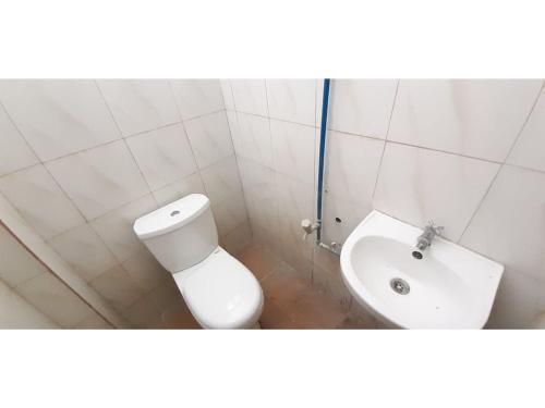 een witte badkamer met een toilet en een wastafel bij OYO 558 Edilberto's Place in Tagum