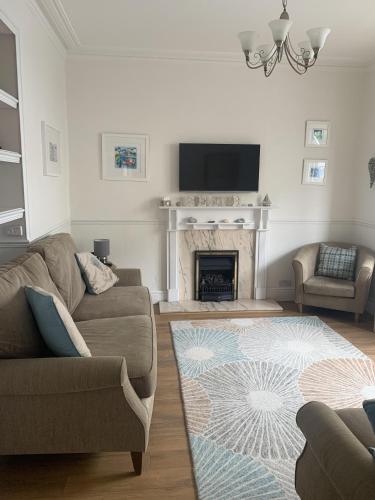 a living room with a couch and a fireplace at Perfect base for 8, pets allowed in Tenby