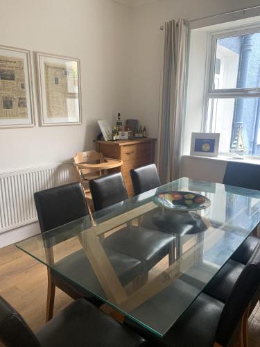 a dining room with a glass table and chairs at Perfect base for 8, pets allowed in Tenby