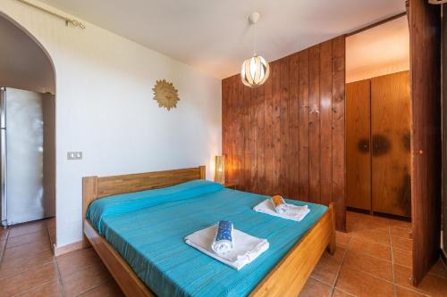 um quarto com uma cama azul com toalhas em Casa Michelle em Villaputzu