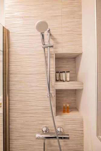 a shower in a bathroom with a wooden wall at RIA Apartments in Mamaia Sat/Năvodari