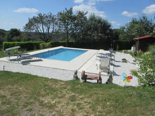 a swimming pool with a bench and a chair at La Ferme de la Chapelle-Saint-Jean in Beynat