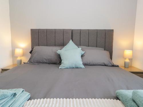 a large bed with a blue pillow on it at 26 Hycemoor Way in Millom