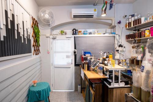 a kitchen with a counter and a table in a room at Sip N' Camp in Bangkok