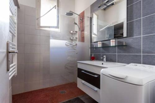 a white bathroom with a sink and a shower at Au repère d'Argante in Pézenas